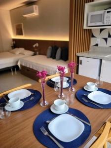 a table with plates and bowls and vases on it at Garvey Park Hotel - Quarto Premium 409 in Brasilia