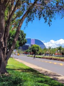 a person walking down a street next to a tree at Garvey Park Hotel - Quarto Premium 409 in Brasilia
