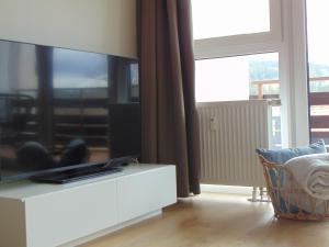 una sala de estar con una gran TV en un armario blanco en Theos, en Hahnenklee-Bockswiese
