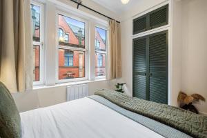 1 dormitorio con 2 ventanas y 1 cama con sábanas blancas en Stylish 1 Bed City Centre Apartment (Sleeps 4) en Newcastle
