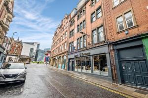 a city street with buildings and a car parked on the street at Stylish 1 Bed City Centre Apartment (Sleeps 4) in Newcastle upon Tyne