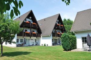 a large building with two roofs and a yard at Ferienwohnung-Stricker-3-3 in Walkenried
