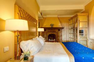 
a bedroom with a bed and a fireplace at Villa Tolomei Hotel & Resort in Florence
