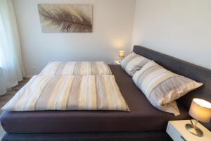 een bed met twee kussens in een slaapkamer bij Ferienhaus Wattschnecke Norddeich in Norddeich