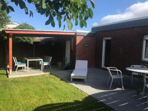 een patio met stoelen en een tafel en tafels bij Ferienhaus Wattschnecke Norddeich in Norddeich