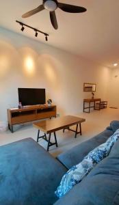 - un salon avec une télévision, un canapé et une table dans l'établissement EzyGo Homestay Kuching - P'Residence, à Kuching