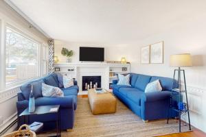 a living room with two blue couches and a fireplace at Salty Shores in Falmouth