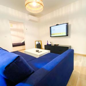 Il comprend un salon doté d'un canapé bleu et d'une télévision à écran plat. dans l'établissement Superbe T2 calme & confortable - très bien situé!, à Ajaccio