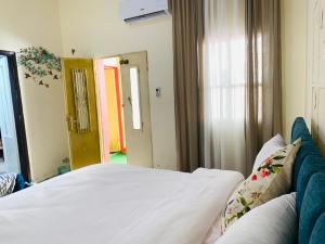 a bedroom with a bed with white sheets and a window at Laura's Cozy HOME in Madaba