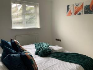 an unmade bed in a white room with a window at London Road in Earley