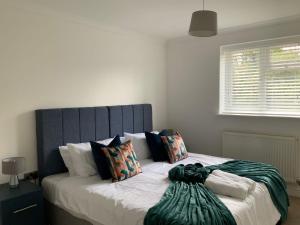 a bed with a blue headboard in a bedroom at London Road in Earley