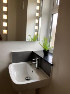 a white sink in a bathroom with a mirror at London Road in Earley