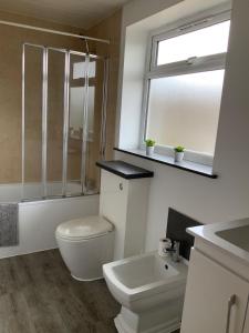 a bathroom with a toilet and a sink and a window at London Road in Earley