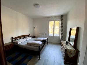 1 dormitorio con 2 camas, tocador y espejo en Casa vacanze Porto Valtravaglia Lago Maggiore en Porto Valtravaglia