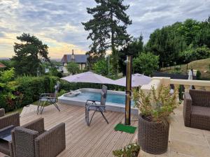 un patio con sombrilla, sillas y piscina en la source de bougival, en Bougival