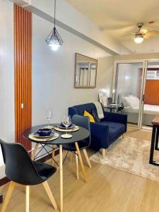 a living room with a blue couch and a table at Weston 1 bedroom Unit with Balcony in Manila