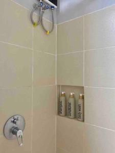 a shower with three shampoo bottles in a bathroom at Weston 1 bedroom Unit with Balcony in Manila