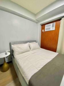a small bedroom with a bed with a window at Weston 1 bedroom Unit with Balcony in Manila