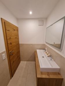 a bathroom with a white sink and a mirror at Dahoam by Tani in Oberndorf in Tirol