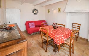 een woonkamer met een tafel en een rode bank bij Lovely Home In Malaucne With Kitchen in Malaucène
