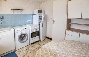 een keuken met een wasmachine en een koelkast bij Lovely Home In Malaucne With Kitchen in Malaucène