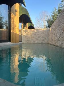 uma piscina em frente a uma parede de pedra em PRİME SUİTES em Yalova