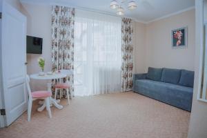 a living room with a blue couch and a table at Hotel&Restaurant Premium Club in Yaremche