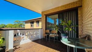 a balcony with a glass table and a potted plant at Carlton 3 beds unit - free parking in Sydney