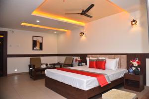 a bedroom with a large bed and a ceiling fan at M R Residency Dharwad. in Dhārwād