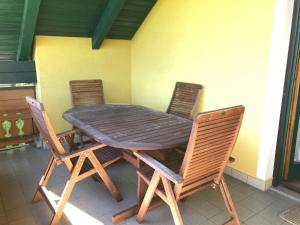 a wooden table and four chairs on a patio at Bauernhof Podorn - Ferienwohnung Panoramablick in Sankt Kanzian