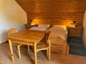 a wooden room with a table and two beds at Bauernhof Podorn - Ferienwohnung Panoramablick in Sankt Kanzian