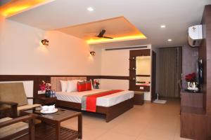 a hotel room with a bed and a living room at M R Residency Dharwad. in Dhārwād