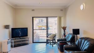 a living room with two chairs and a television at Carlton 3 beds unit - free parking in Sydney