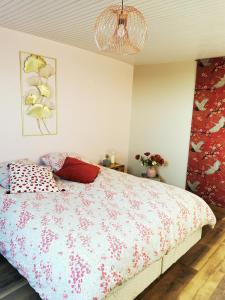 1 Schlafzimmer mit einem Bett mit Blumendecke in der Unterkunft Domaine de l'espérance, chambre rose in Bersaillin