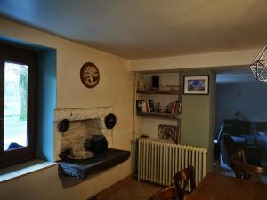ein Wohnzimmer mit Kamin und ein Esszimmer in der Unterkunft Domaine de l'espérance, chambre rose in Bersaillin