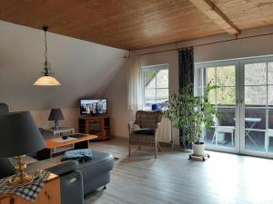 una sala de estar con un sofá y una mesa en Ferienwohnung-Stricker-3-2, en Walkenried