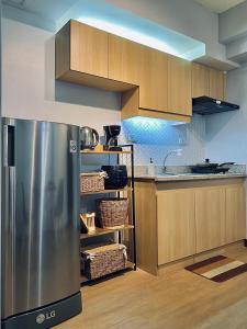 a kitchen with a stainless steel refrigerator and wooden cabinets at Weston 1 bedroom Unit with Balcony in Manila