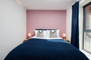 - une chambre avec un lit bleu et une fenêtre dans l'établissement Beaut 5 Bed House w Parking, à Manchester