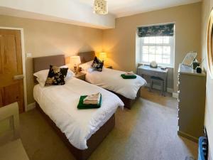 a hotel room with two beds and a window at Honey Cottage in Gargrave
