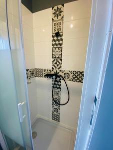 ein Bad mit einer Dusche und einer Fliesenwand in der Unterkunft Chambre ZEN proche de Bagnoles de lOrne in La Ferté-Macé