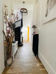 einen Flur mit einer Treppe und ein Zimmer mit einer Vase in der Unterkunft Chambre ZEN proche de Bagnoles de lOrne in La Ferté-Macé
