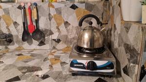 a tea kettle on top of a stove on a counter at Dalinda's Homestay in Puerto Princesa City