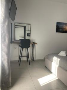 een slaapkamer met een bed, een bureau en een stoel bij Evis House in Chania