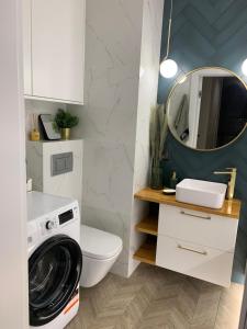 a bathroom with a washing machine and a mirror at Forest Apart I in Warsaw