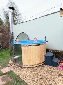 two people in a hot tub in a backyard at The Old Gasworks in Milverton