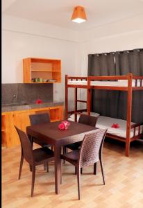 Zimmer mit einem Tisch, Stühlen und einem Etagenbett in der Unterkunft Siargao Sunrise Villa in General Luna