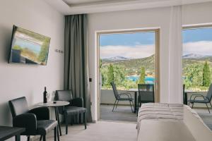 a room with a bed and a balcony with a view at Lighthouse Apartments in Stoupa