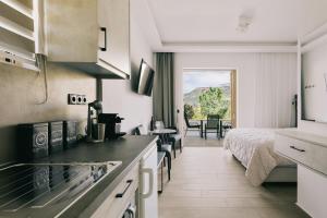 a kitchen with a bed and a room with a bed at Lighthouse Apartments in Stoupa