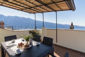 una mesa en un balcón con vistas a las montañas en Casa Marianna by Garda FeWo, en Tignale