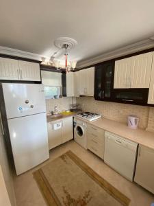 a kitchen with a white refrigerator and a dishwasher at Bodrum 3 bedrooms family villa dublex in Bodrum City